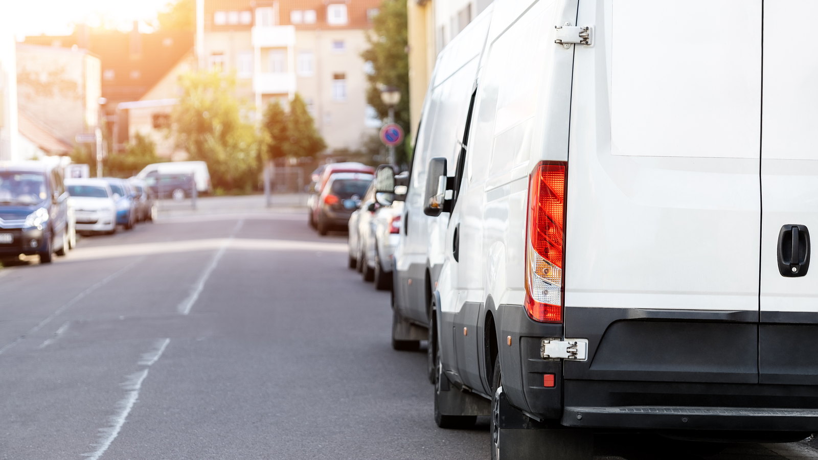Plain white work van parked on a residential street with no branding on it