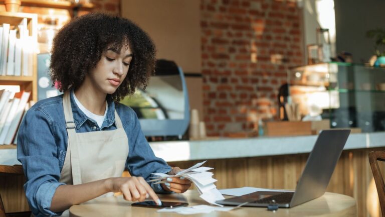 Small business owner reviewing monthly bills and website costs on a laptop